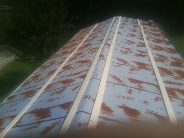 Rusted metal roof panels with new wood purlins before replacement — Storm Damage Roof Repair in Arkport by Roofing Brothers