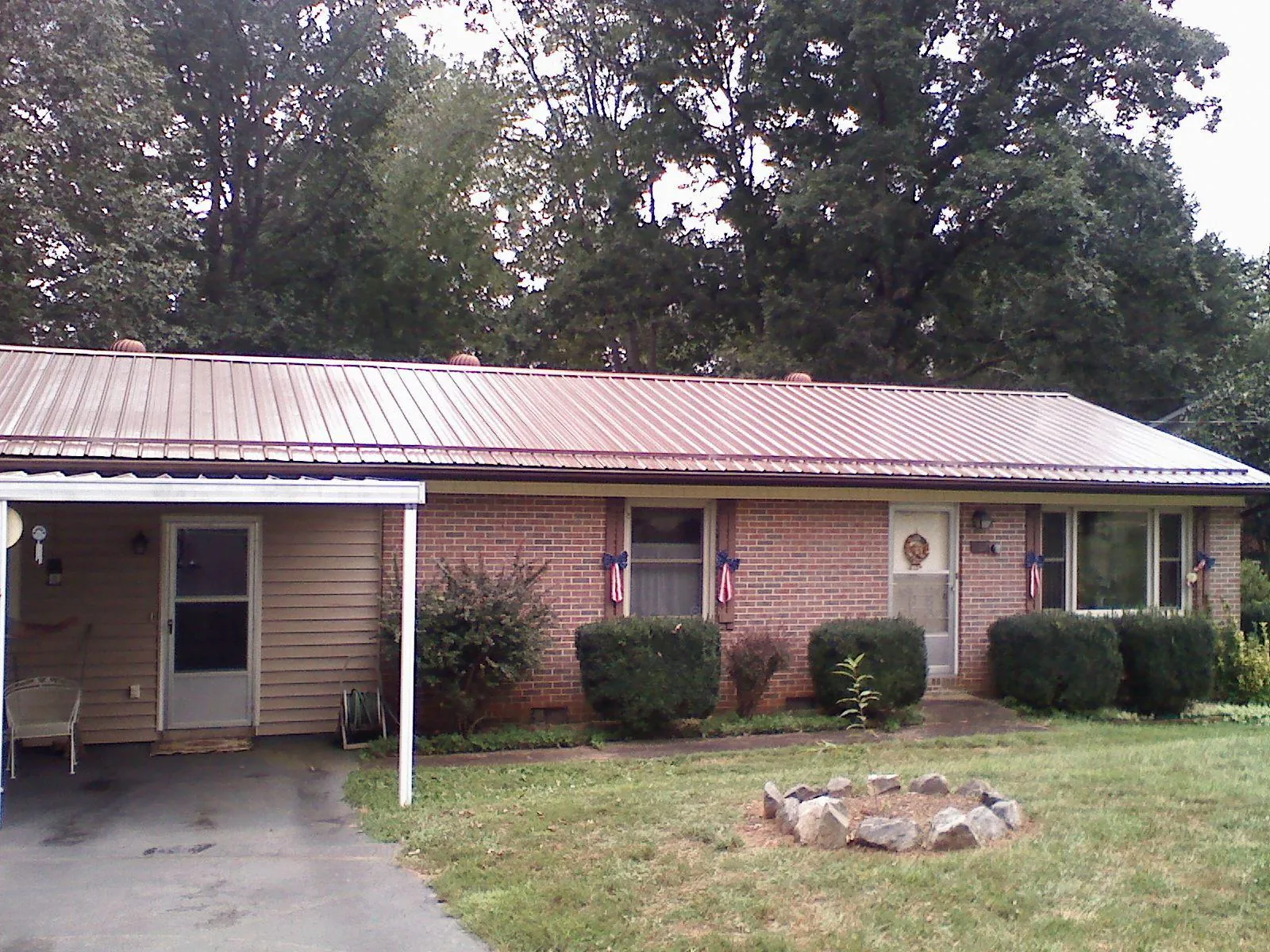 Bronze metal roof and carport on a brick ranch home — Roof Repair work by our crew in Arkport
